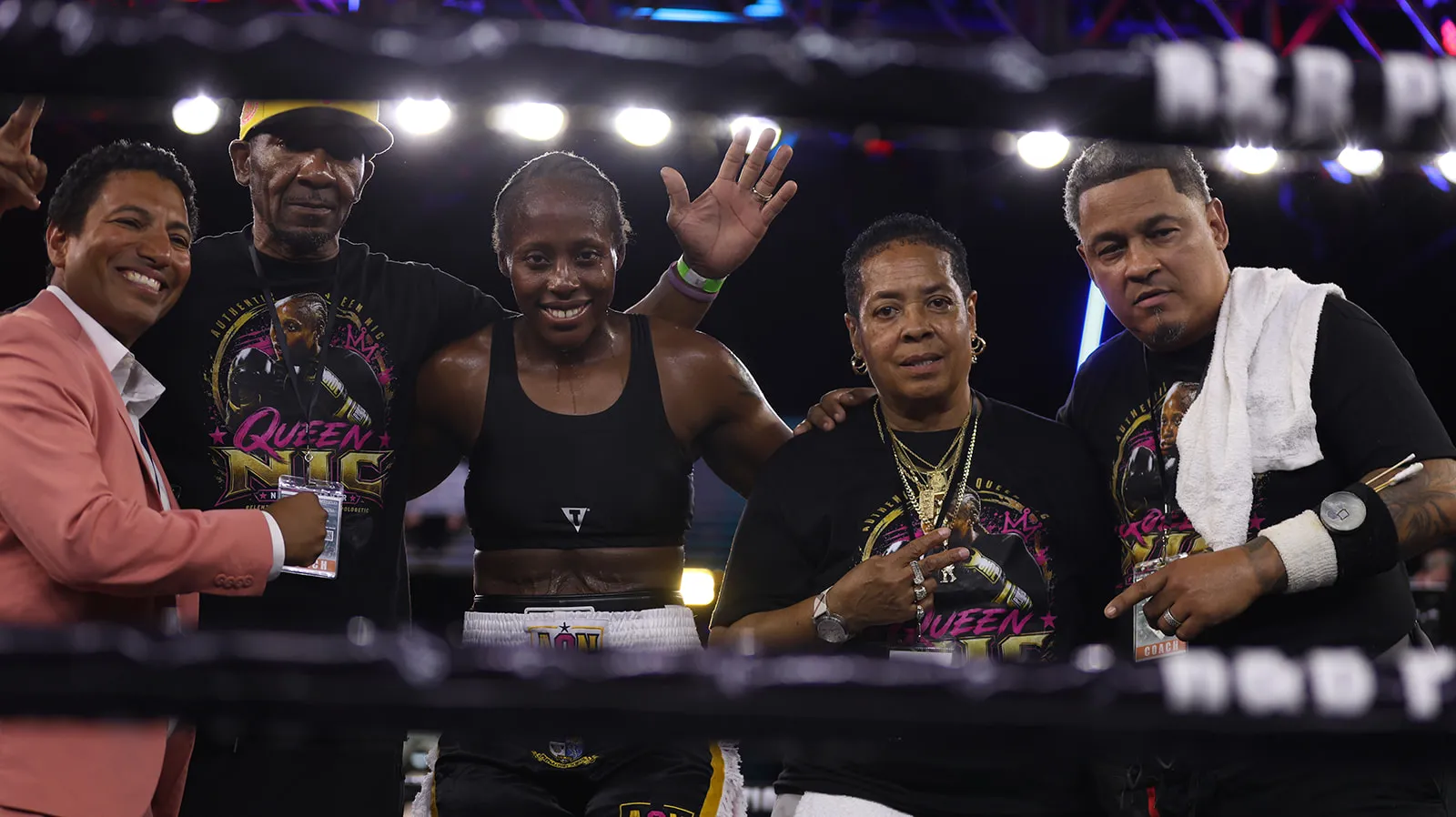 Fisher in the ring after the decision with her corner team and an interviewer, everyone smiling.