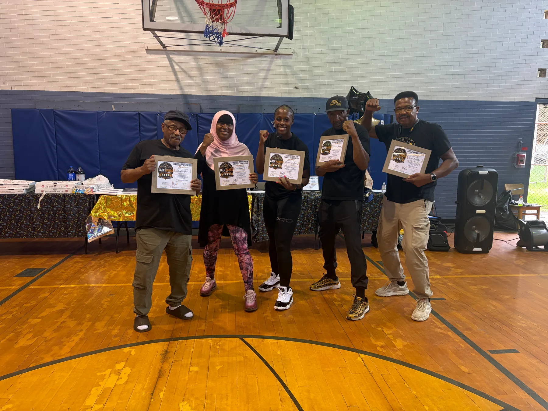 Five adults holding framed coach and founder appreciation awards from Knockout Gun Violence Inc.